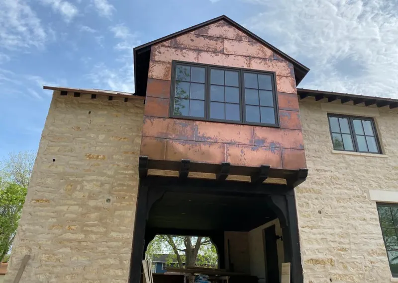Copper metal panel facade on a stone building for Roof Repair in South Kingstown