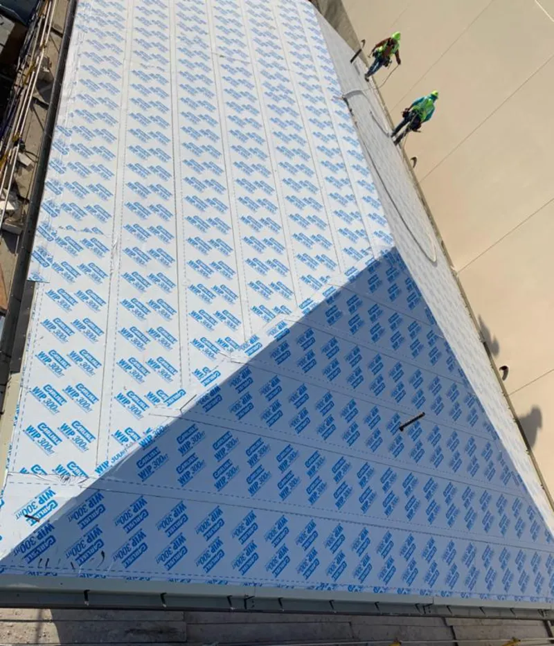 Professional roofers installing underlayment on a metal roof in South Kingstown